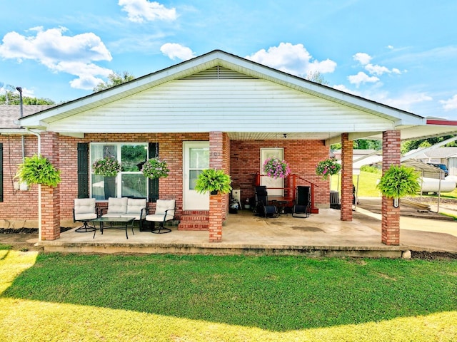 18189 2nd St, Eminence, MO 65466 - rear view of property featuring a yard, a patio area, an outdoor living space, and brick siding