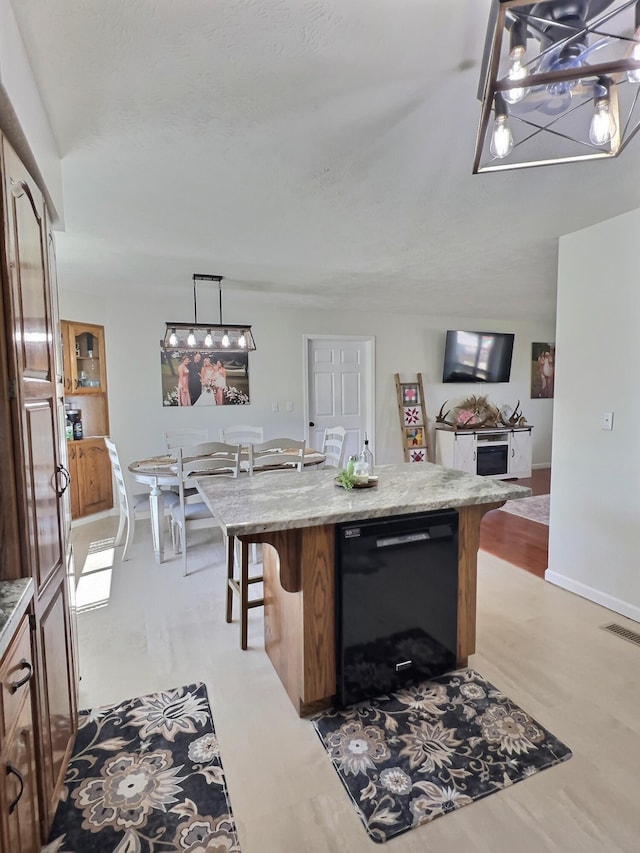18189 2nd St, Eminence, MO 65466 - kitchen with black dishwasher, a chandelier, a breakfast bar area, a center island, and decorative light fixtures