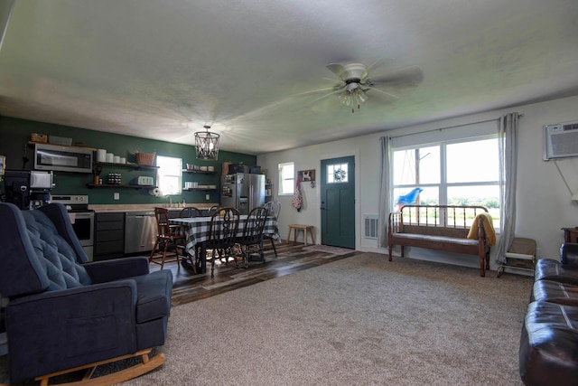 361 Durington Rd, Buffalo, MO 65622 - carpeted living area featuring a ceiling fan, a wall mounted air conditioner, and a chandelier