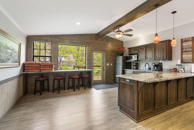 7815 Cozy Cove Rd Unit 3-15, Branson, MO 65616 - kitchen with a peninsula, a kitchen breakfast bar, stainless steel appliances, light wood-type flooring, and light stone countertops