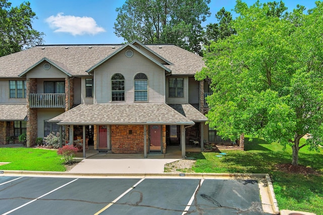 7815 Cozy Cove Rd Unit 3-15, Branson, MO 65616 - view of front of house with covered porch, uncovered parking, stone siding, a shingled roof, and a front yard
