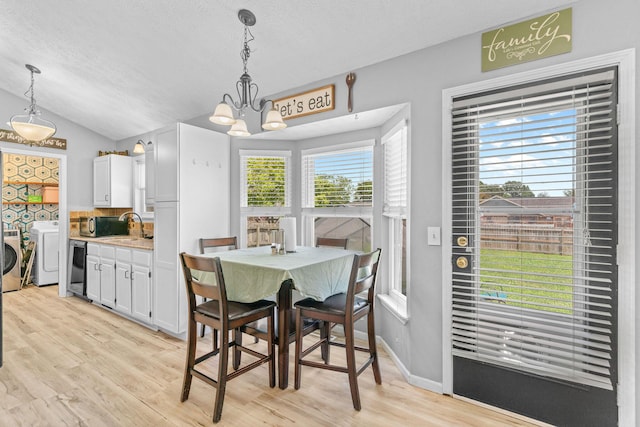 208 S Poplar Ct, Nixa, MO 65714 - dining space with separate washer and dryer, a chandelier, light wood finished floors, lofted ceiling, and a textured ceiling
