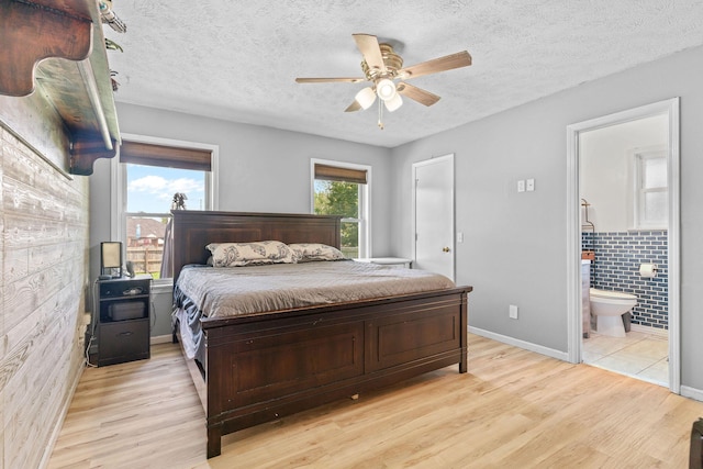 208 S Poplar Ct, Nixa, MO 65714 - bedroom featuring light wood-style floors, ensuite bathroom, a textured ceiling, and ceiling fan
