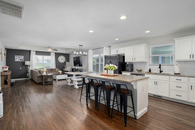 504 Gauge St, Willard, MO 65781 - kitchen featuring freestanding refrigerator, a breakfast bar area, open floor plan, a center island, and white cabinets
