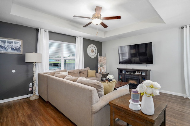 504 Gauge St, Willard, MO 65781 - living area featuring a raised ceiling, dark wood finished floors, ceiling fan, and a fireplace