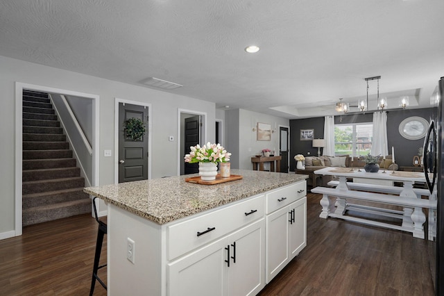 504 Gauge St, Willard, MO 65781 - kitchen with a breakfast bar, a kitchen island, dark wood-type flooring, white cabinetry, and open floor plan