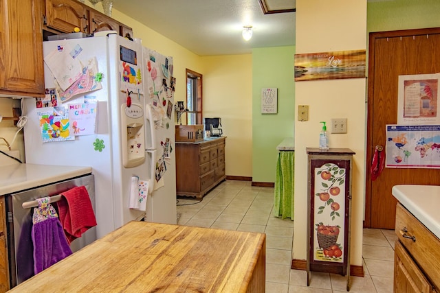 1746 Wall Rd, Mountain Grove, MO 65711 - kitchen with freestanding refrigerator, light tile patterned floors, light countertops, and brown cabinets