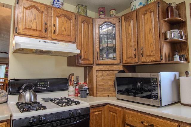 1746 Wall Rd, Mountain Grove, MO 65711 - kitchen featuring range with gas stovetop, stainless steel microwave, under cabinet range hood, brown cabinets, and open shelves