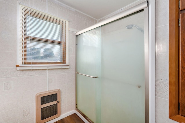 304 N Main St, Lockwood, MO 65682 - bathroom featuring heating unit, a stall shower, ornamental molding, tile walls, and wood finished floors