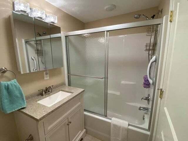203 Forest Park Ln, Branson, MO 65616 - full bathroom featuring vanity and combined bath / shower with glass door