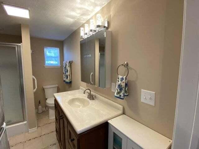 203 Forest Park Ln, Branson, MO 65616 - bathroom with vanity, a shower stall, and tile patterned floors