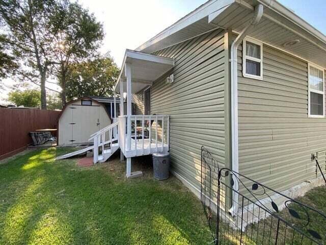 203 Forest Park Ln, Branson, MO 65616 - view of side of home featuring a storage unit and a wooden deck