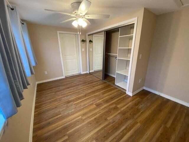 203 Forest Park Ln, Branson, MO 65616 - unfurnished bedroom featuring wood finished floors and ceiling fan