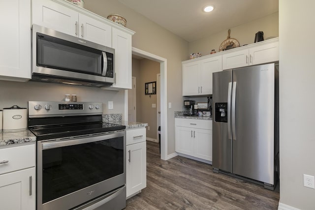 1929 N Brookhollow Dr, Nixa, MO 65714 - kitchen with appliances with stainless steel finishes, white cabinetry, dark wood-type flooring, light stone counters, and recessed lighting