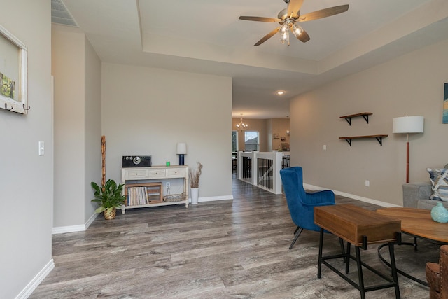 1929 N Brookhollow Dr, Nixa, MO 65714 - living area featuring a chandelier, wood finished floors, a ceiling fan, and a raised ceiling