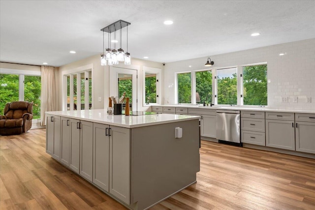 103 W Secluded Ln, Nixa, MO 65714 - kitchen with dishwasher, gray cabinetry, light wood finished floors, a kitchen island, and light countertops