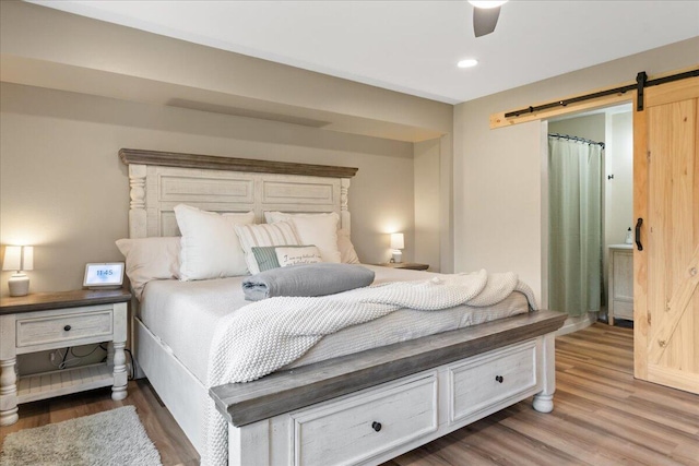 103 W Secluded Ln, Nixa, MO 65714 - bedroom with a barn door, wood finished floors, ceiling fan, and recessed lighting