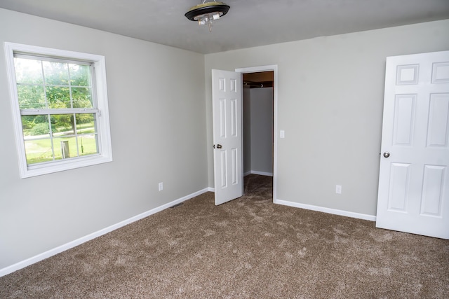 1719 N Pine St, Marshfield, MO 65706 - unfurnished bedroom featuring dark carpet and a spacious closet
