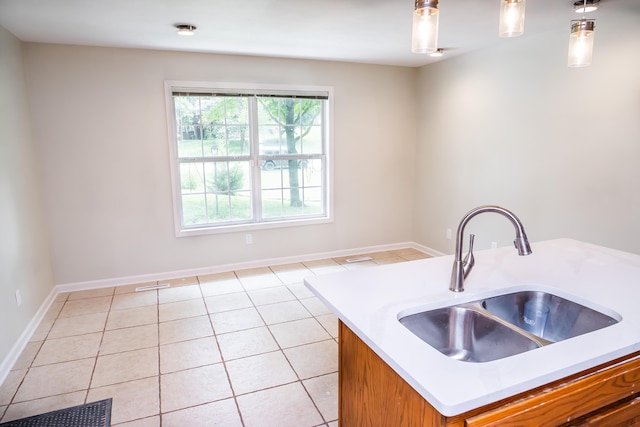1719 N Pine St, Marshfield, MO 65706 - kitchen with brown cabinetry, light countertops, light tile patterned flooring, and hanging light fixtures