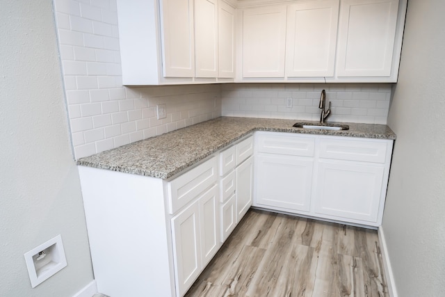 1719 N Pine St, Marshfield, MO 65706 - kitchen featuring decorative backsplash, light wood-style flooring, and white cabinetry