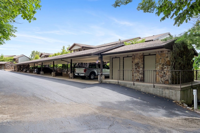 348 Sunset Cv Unit 413, Branson, MO 65616 - view of home's exterior with stone siding, roof with shingles, and covered parking