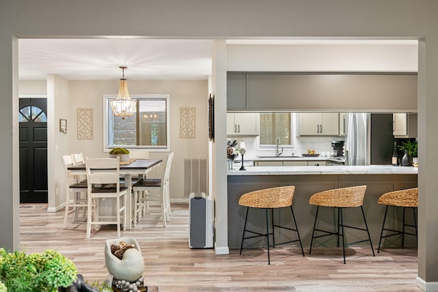 348 Sunset Cv Unit 413, Branson, MO 65616 - kitchen featuring light wood-style flooring, a breakfast bar, tasteful backsplash, and healthy amount of natural light