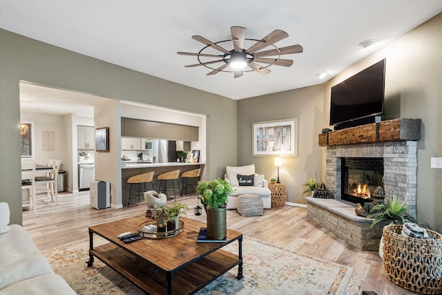 348 Sunset Cv Unit 413, Branson, MO 65616 - living room featuring ceiling fan, light wood-style floors, and a stone fireplace