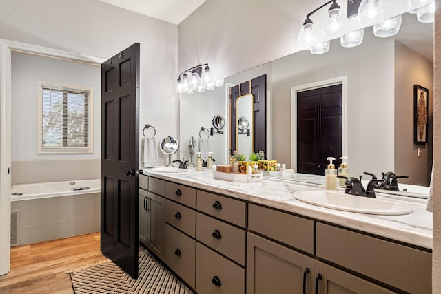 348 Sunset Cv Unit 413, Branson, MO 65616 - bathroom with double vanity, a garden tub, and wood finished floors