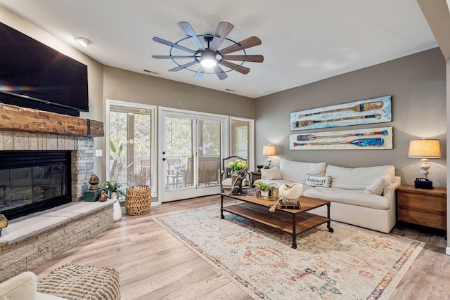 348 Sunset Cv Unit 413, Branson, MO 65616 - living area with a ceiling fan, wood finished floors, and a stone fireplace