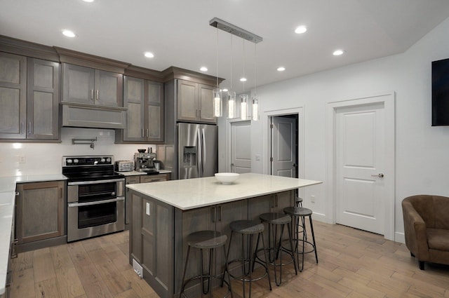 4113 S Farm Rd Unit 223, Rogersville, MO 65742 - kitchen featuring stainless steel appliances, light wood finished floors, a kitchen bar, a kitchen island, and recessed lighting