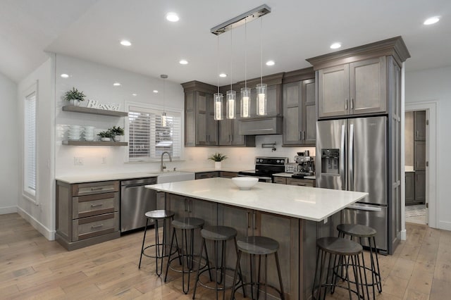 4113 S Farm Rd Unit 223, Rogersville, MO 65742 - kitchen with stainless steel appliances, light wood-style floors, a breakfast bar area, light countertops, and recessed lighting
