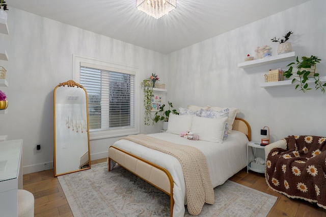 4113 S Farm Rd Unit 223, Rogersville, MO 65742 - bedroom with wood-type flooring and a chandelier