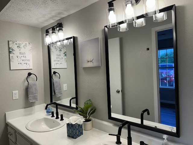 17 Fall Creek Trl Unit 4, Branson, MO 65616 - bathroom with double vanity, a textured ceiling, a textured wall, and a chandelier