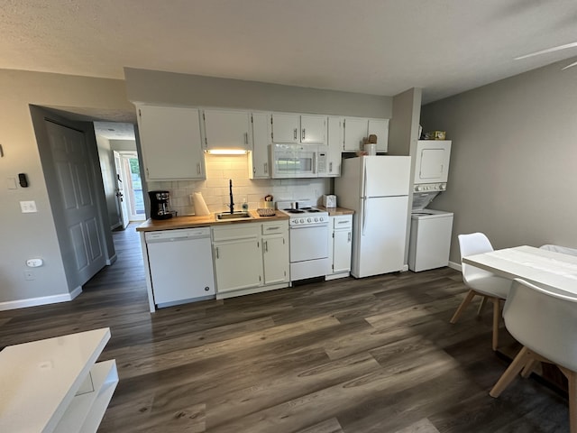 17 Fall Creek Trl Unit 4, Branson, MO 65616 - kitchen with white appliances, stacked washer / dryer, dark wood finished floors, and decorative backsplash