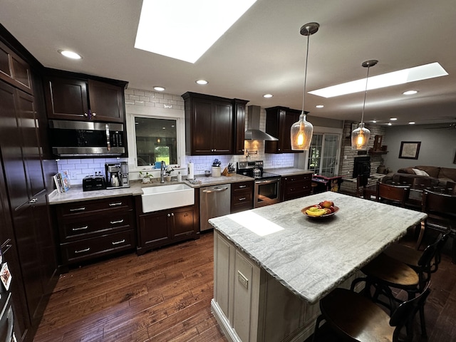 1179 N Pine St, Marshfield, MO 65706 - kitchen featuring a skylight, appliances with stainless steel finishes, wall chimney range hood, tasteful backsplash, and recessed lighting