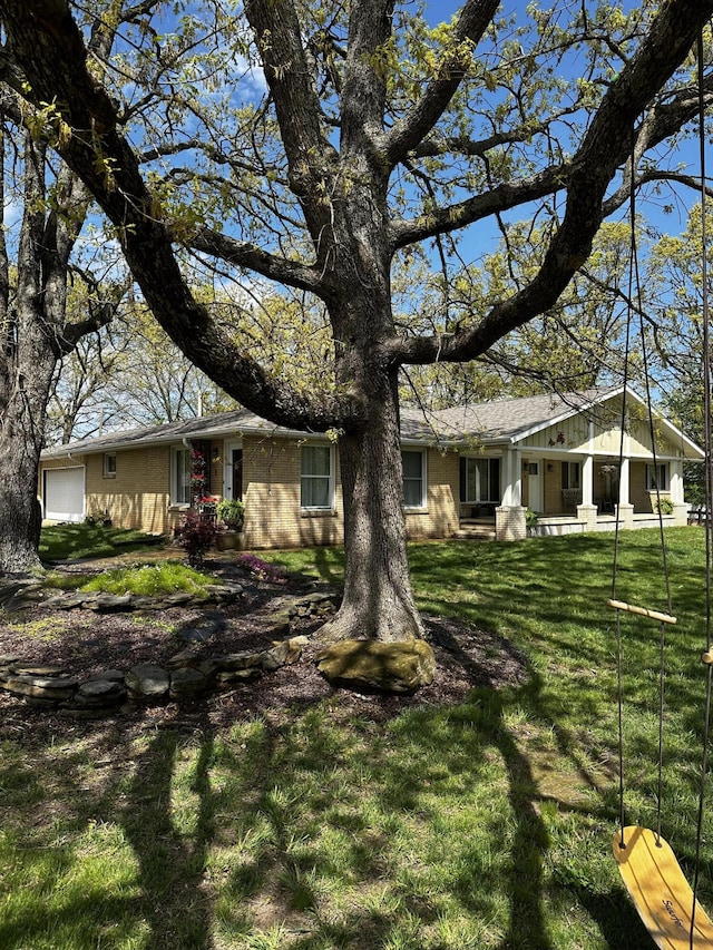 1179 N Pine St, Marshfield, MO 65706 - view of front of home featuring a front lawn, brick siding, and a garage