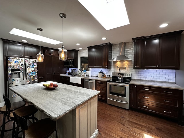 1179 N Pine St, Marshfield, MO 65706 - kitchen featuring wall chimney range hood, stainless steel appliances, a skylight, tasteful backsplash, and dark brown cabinets