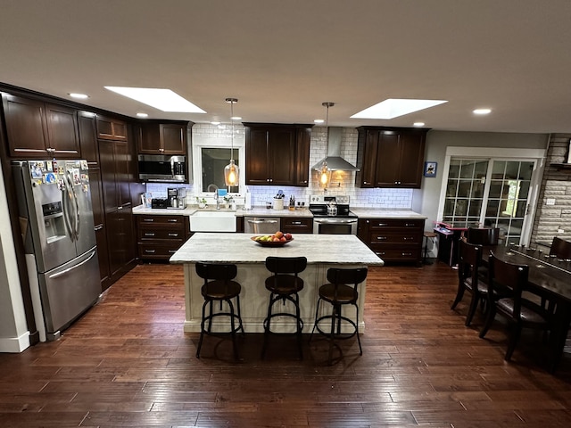 1179 N Pine St, Marshfield, MO 65706 - kitchen featuring a skylight, appliances with stainless steel finishes, wall chimney exhaust hood, dark brown cabinetry, and recessed lighting