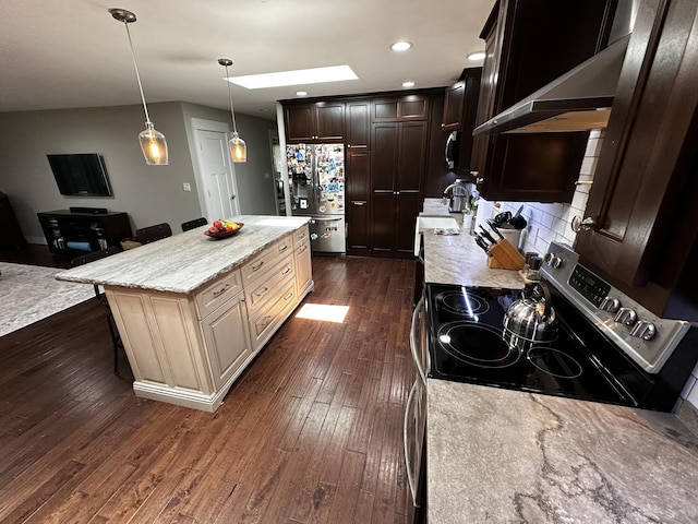 1179 N Pine St, Marshfield, MO 65706 - kitchen featuring refrigerator with ice dispenser, dark wood-style flooring, a kitchen bar, a center island, and light stone counters