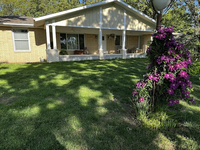 1179 N Pine St, Marshfield, MO 65706 - rear view of property with brick siding, a yard, and covered porch