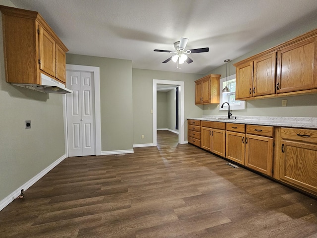 609 S College St, Neosho, MO 64850 - kitchen featuring dark wood-style floors, ceiling fan, light countertops, brown cabinets, and pendant lighting