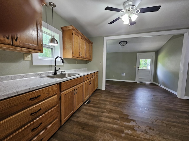 609 S College St, Neosho, MO 64850 - kitchen with brown cabinetry, dark wood-type flooring, ceiling fan, and hanging light fixtures