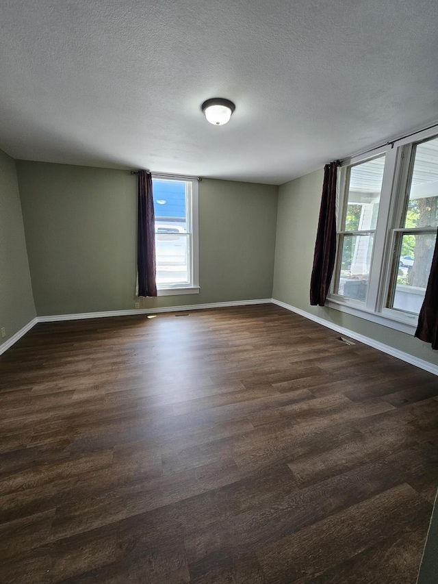609 S College St, Neosho, MO 64850 - spare room with dark wood finished floors and a textured ceiling