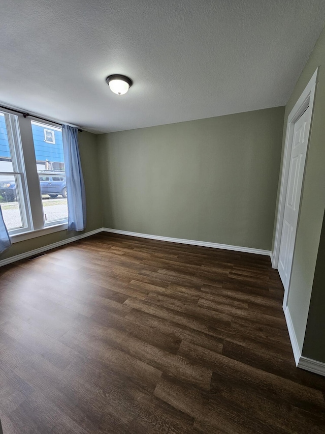 609 S College St, Neosho, MO 64850 - empty room with dark wood-type flooring and a textured ceiling