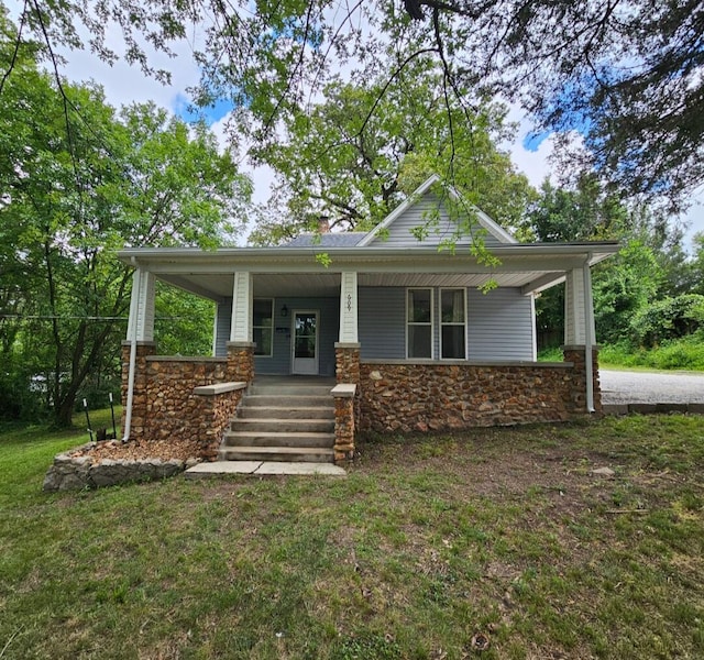 609 S College St, Neosho, MO 64850 - view of front facade featuring stone siding, a porch, and a front yard