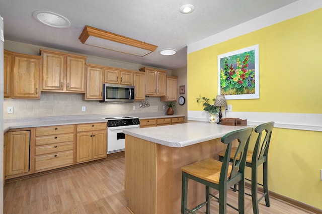 1060 Berkley, Marshfield, MO 65706 - kitchen with white electric range oven, stainless steel microwave, light countertops, tasteful backsplash, and a kitchen bar