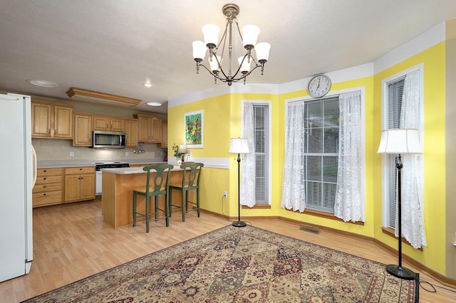 1060 Berkley, Marshfield, MO 65706 - kitchen with white appliances, light wood-type flooring, light countertops, a chandelier, and a peninsula