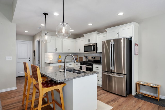 816 S Rockburn Ct, Nixa, MO 65714 - kitchen with stainless steel appliances, tasteful backsplash, light wood-style flooring, white cabinets, and recessed lighting