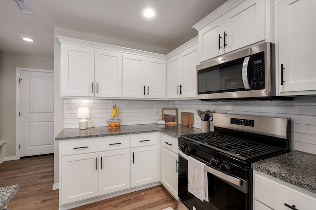 816 S Rockburn Ct, Nixa, MO 65714 - kitchen with stainless steel appliances, dark stone counters, white cabinetry, light wood finished floors, and recessed lighting