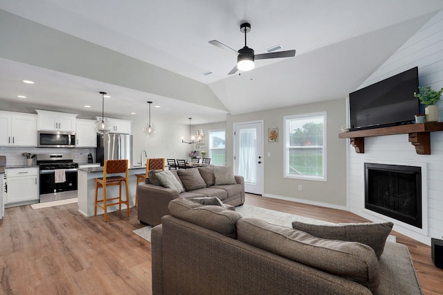 816 S Rockburn Ct, Nixa, MO 65714 - living area with lofted ceiling, light wood-style flooring, a large fireplace, ceiling fan, and recessed lighting
